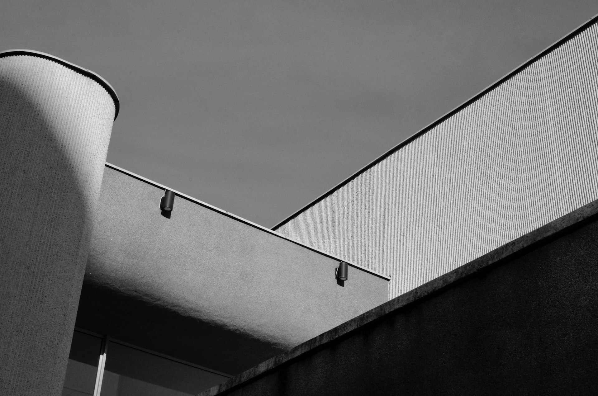 a grey building with a metal pole